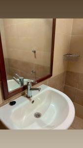 a bathroom sink with a large mirror above it at GREENFIELD STUDlO DONHOLM in Nairobi