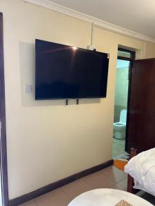 a flat screen tv hanging on a wall at GREENFIELD STUDlO DONHOLM in Nairobi
