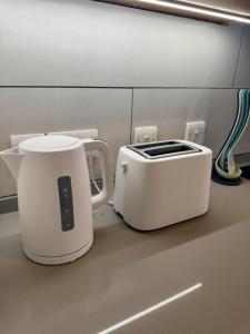 two white appliances sitting on a counter in a kitchen at Europa Point Area Townhouse in Gibraltar
