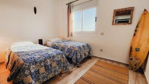 a bedroom with two beds and a window at La Cabane Surf Lodge in Agadir