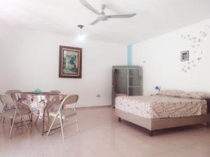 a bedroom with a bed and a table and chairs at Sisal Brisa de Mar in Sisal +9 photos