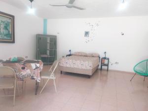 a bedroom with a bed and a table and chairs at Sisal Brisa de Mar in Sisal