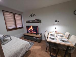a dining room with a table and a fireplace at Bela Reka 204 in Brzeće