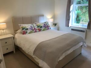 a bedroom with a white bed with a pillow and a window at Conaglen, Glenloch View, Fort William 2-Bedroom Loch Side Flat in Fort William