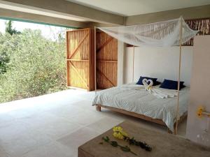 a bedroom with a bed with a mosquito net at Casa Chukum - Retreat House - Agua Blanca in Playa Agua Blanca