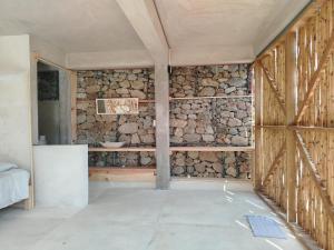 a room with a stone wall at Casa Chukum - Retreat House - Agua Blanca in Playa Agua Blanca +29 photos