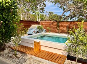 a small swimming pool with a wooden bench and a car at Casa Chukum - Retreat House - Agua Blanca in Playa Agua Blanca