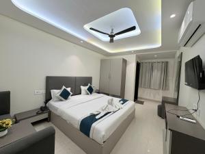a bedroom with a large bed and a tv at Hotel Synergy Stays in Indore