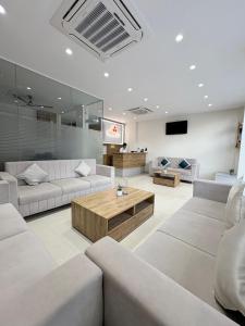 a living room with white couches and a table at Hotel Synergy Stays in Indore