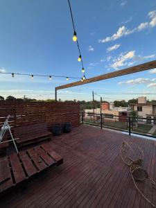 a wooden deck with a bench and a brick wall at Casa Susana in Jesús María