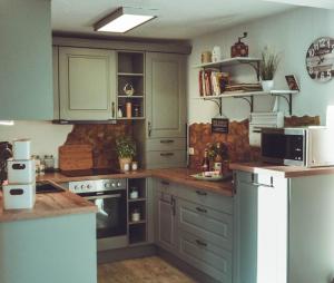 a kitchen with green cabinets and a stove top oven at Ferienhaus Vogtland mit Sauna und Hot Tub in Weischlitz +38 photos