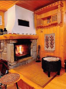 a living room with a stone fireplace and a table at Góralski domek z kominkiem w dużym ogrodzie pełnym zieleni w spokojnej okolicy, blisko atrakcji Podhala in Łopuszna