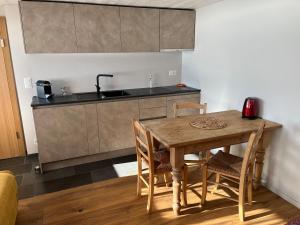 a kitchen with a wooden table with chairs and a sink at Chalet Les Marmouzets in Gryon