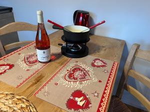 a wooden table with a bottle of wine and a mortar and pestle at Chalet Les Marmouzets in Gryon
