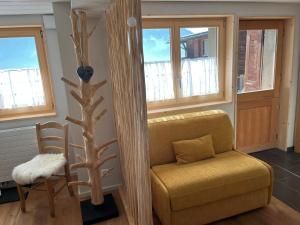 a living room with a couch and a chair and windows at Chalet Les Marmouzets in Gryon