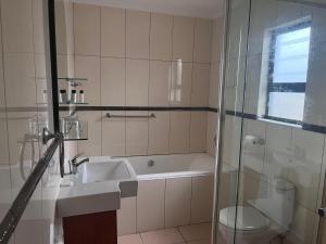 a bathroom with a tub and a sink and a toilet at Simlily Place in East London