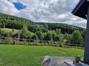 a yard with a view of a hill with trees at Przystań w górskim Raju in Bolesławów