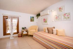 a bedroom with a bed and a chair and a window at Wine & Vineyard Retreat Emarmene in Koskinou +57 photos