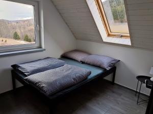 a bed in a small room with two windows at Przystań w górskim Raju in Bolesławów +7 photos