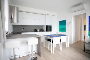 a kitchen with white cabinets and a table and chairs at Marion's Apartment in Riva di Solto