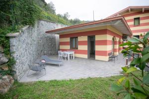a house with a patio with a table and chairs at Marion's Apartment in Riva di Solto