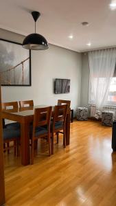 a dining room with a wooden table and chairs at Acogedor piso céntrico in Lugo +10 photos