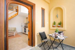 a dining room with a table and chairs and a staircase at Wine & Vineyard Retreat Emarmene in Koskinou