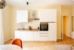 a kitchen with white cabinets and a sink and a microwave at Monti26 in Milan +6 photos