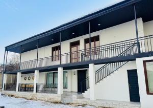 a white building with balconies and stairs on it at Amavilla Hotel in Telavi