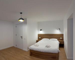 a bedroom with a bed with a wooden headboard at Amavilla Hotel in Telavi +23 photos