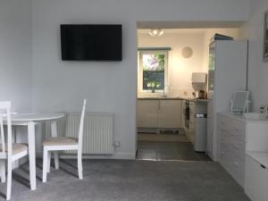 a kitchen and dining room with a table and a television on the wall at Flat 2 Frank Lewis House in Hay-on-Wye +10 photos