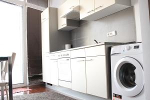 a white laundry room with a washer and dryer at Kukucinova Apartments in Bratislava