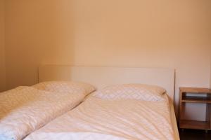 a bed with two pillows on it next to a table at Kukucinova Apartments in Bratislava