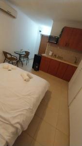 a bedroom with a white bed and a table and chairs at גאון מול המדבר in Arad