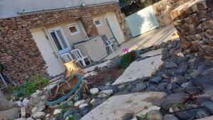 a house with a stone wall and a building at גאון מול המדבר in Arad