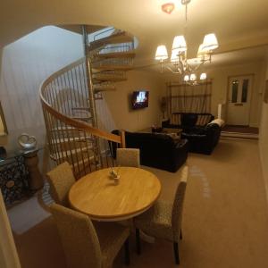 a living room with a table and a spiral staircase at Foxy stays in Tanfield