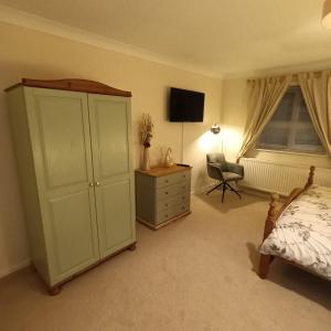 a bedroom with a bed and a dresser and a chair at Foxy stays in Tanfield