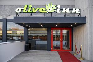 a building with a red door and a sign on it at Olive INN Berlin in Berlin