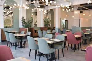 a dining room with tables and chairs and chandeliers at Olive INN Berlin in Berlin
