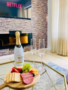 a bottle of champagne and two wine glasses on a table at The Cherry Apartment Nahoon Valley in East London