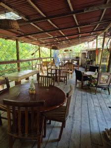 a patio with tables and chairs on a wooden floor at Hotel Eco Point in Minca