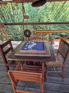 a wooden table and two chairs on a deck at Hotel Eco Point in Minca +77 photos