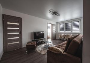 a living room with a couch and a tv and a table at Feliz Stay in Šiauliai