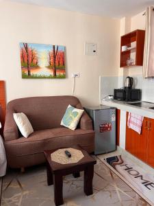 a living room with a couch and a table in a kitchen at Pearl Studio in Machakos