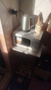 a microwave with a pot on top of it at EL Salam in Hotel Apartment 6 in Sharjah +10 photos