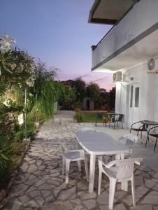a white table and chairs on a stone patio at Anestis Studios in Agios Georgios