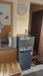 a refrigerator in a room with a clock on the wall at EL Salam in Hotel Apartment 6 in Sharjah