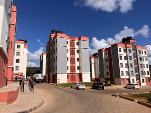 a group of buildings with cars parked on a street at Pearl Studio in Machakos