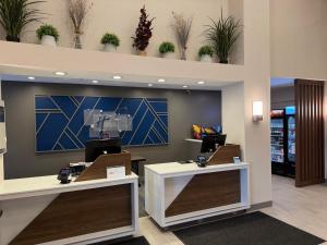 a lobby of a store with two counters with computers at Holiday Inn Express Syracuse-Fairgrounds by IHG in Warners +34 photos