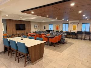a conference room with tables and chairs and a flat screen tv at Holiday Inn Express Syracuse-Fairgrounds by IHG in Warners
